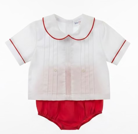 A boys short-sleeve white blouse with a red collar and sleeve trim, paired with red bloomers, hanging on a clear plastic hanger in a retail store.