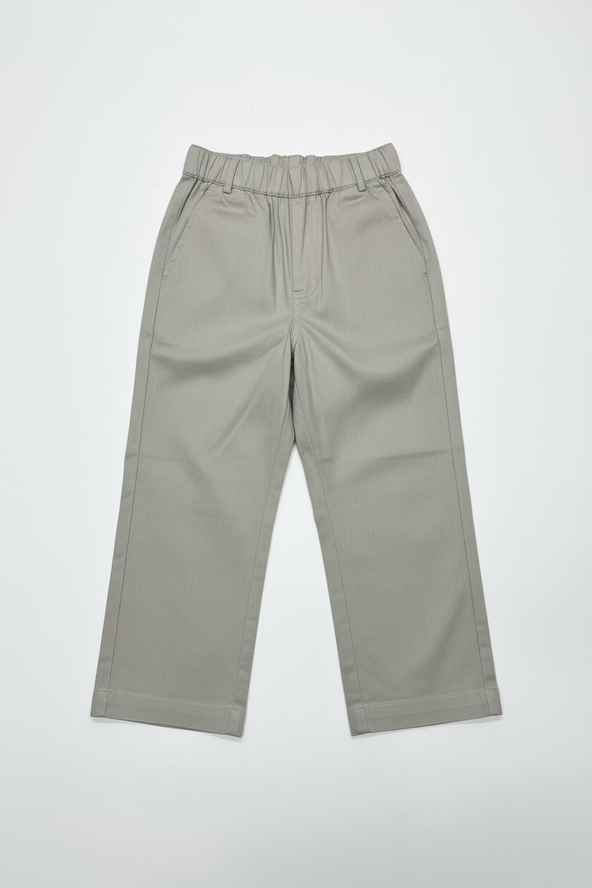 A pair of light beige wide-leg cropped pants hanging on a clear plastic hanger from a store display shelf, with shoe boxes stacked behind them.