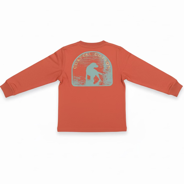 A coral orange long-sleeve t-shirt hanging on a clear plastic hanger, showing the back graphic with a light blue silhouette of a person and the words 'COASTAL COTTON'. The shirt is photographed in a retail or warehouse setting with shoe boxes stacked on shelves in the background.