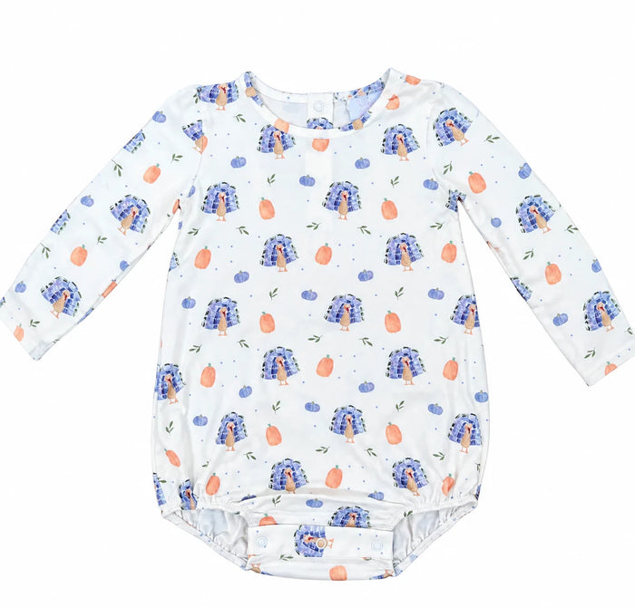 A long-sleeve baby bodysuit with a white base, featuring an all-over print of blue peacock feathers, orange peaches, and small green leaves.