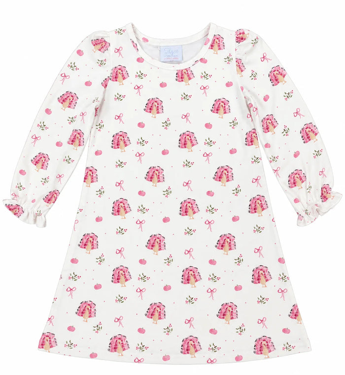 A long-sleeve baby dress with a white base and an all-over print of pink tiered cakes, pink bows, and small pink flowers, shown flat against a white background.