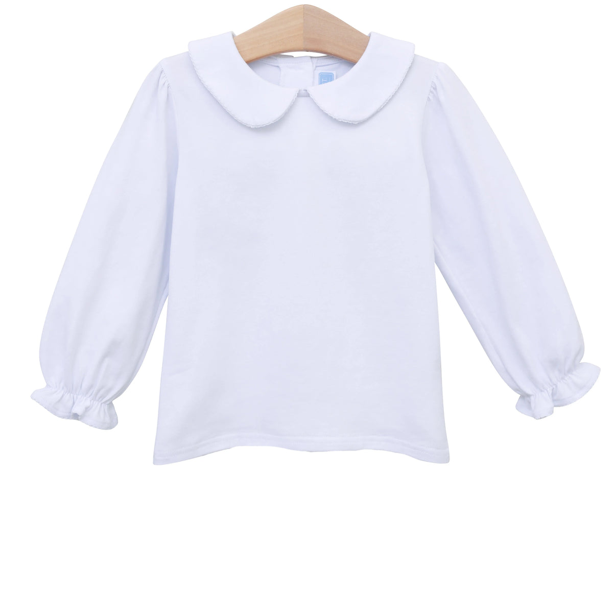 A white long-sleeve baby top with a Peter Pan collar and ruffled cuffs, hanging on a wooden hanger against a white background.