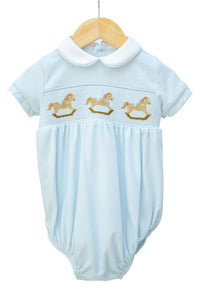 Light blue baby romper with embroidered rocking horses on a white background
