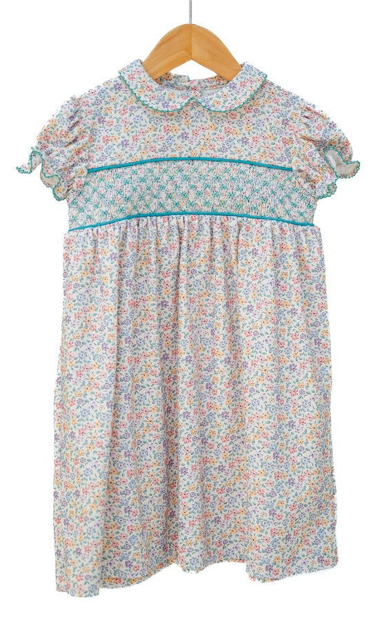 Floral dress on a wooden hanger against a white background