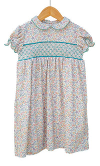 Floral dress on a wooden hanger against a white background