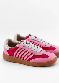 A pair of pink low-top sneakers with a suede and synthetic upper, featuring light pink side stripes, white laces, and brown gum soles, photographed on a light gray background.