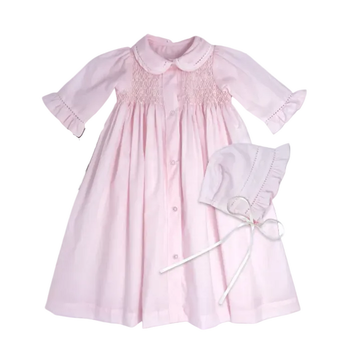 Pink baby dress with matching hat on a gray background