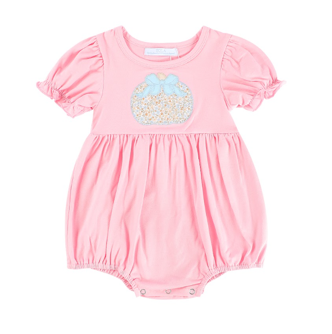 A baby girl's pink short-sleeve bubble romper with a decorative applique of a glittery egg and a light blue bow on the chest, set against a plain white background.