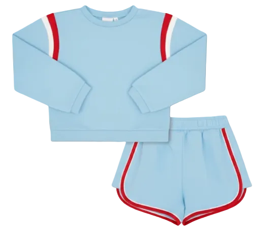A two-piece kids' athletic set featuring a light blue long-sleeve sweatshirt with red and white sleeve stripes, and matching light blue shorts with red and white side stripes, displayed on a solid white background.