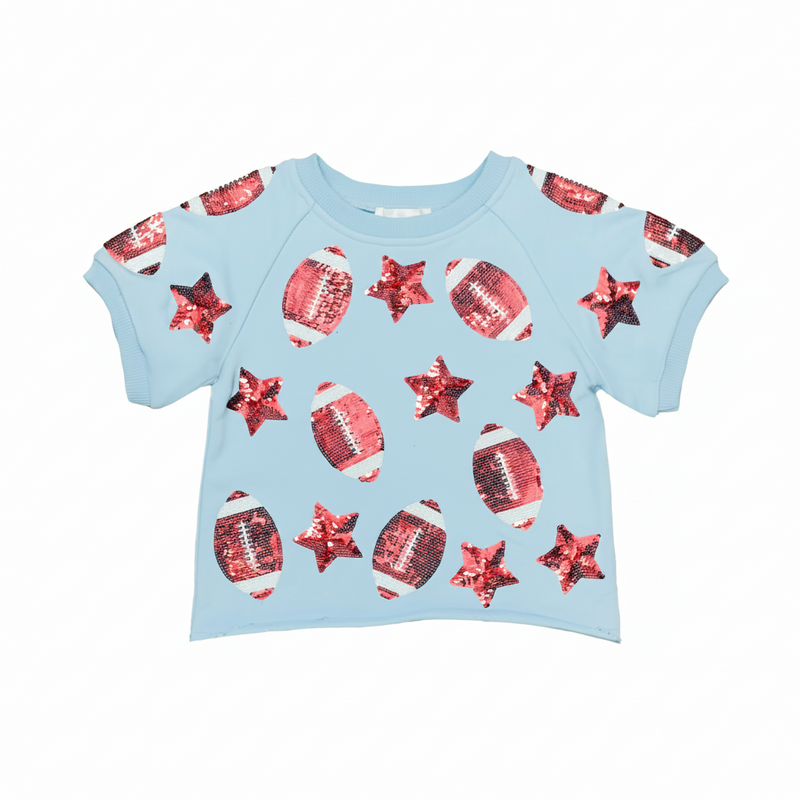 A light blue short-sleeve baby t-shirt featuring an all-over sequined pattern of red footballs and red stars, displayed flat against a white background.