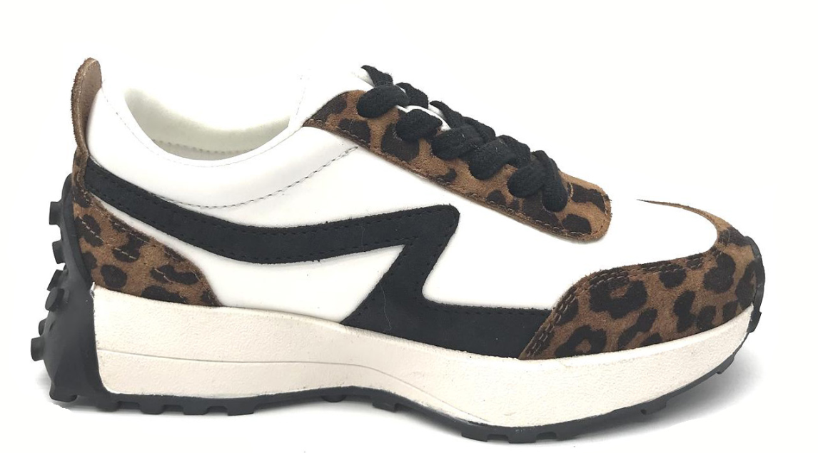 A low-top platform sneaker featuring a white leather base, black suede overlays, and brown leopard-print suede panels on the toe, heel, and laces, set against a plain white background.