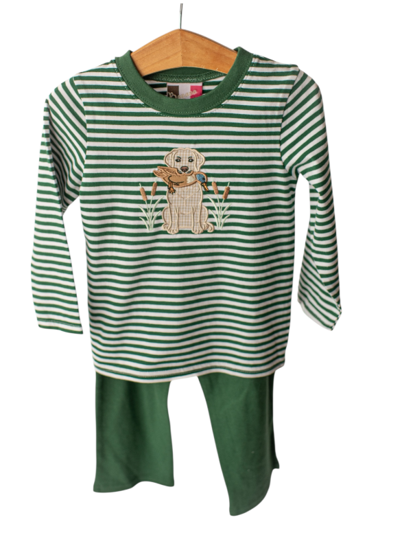 A toddler's two-piece long-sleeve pajama set hanging on a wooden hanger against a white background. The set features a green and white striped long-sleeve top with a central embroidered dog motif, paired with solid green pants.