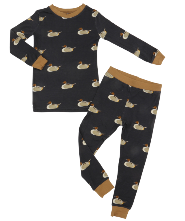 A two-piece children's pajama set featuring a long-sleeve top and matching pants. The pajamas are dark charcoal gray with an all-over duck print, accented with tan trim on the collar, cuffs, and waistband.