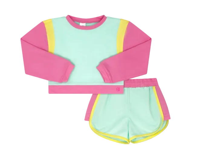 A two-piece kids' athletic set featuring a long-sleeve crop top and matching shorts in mint green, hot pink, and neon yellow. The top has a mint green body, hot pink sleeves and collar, and neon yellow side panels.