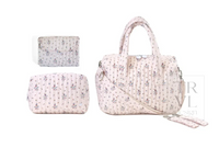 A light pink quilted handbag with a small floral print, shown alongside matching pouches and a strap on a white background. A watermark for 'TRYL Design' is visible on the right side.