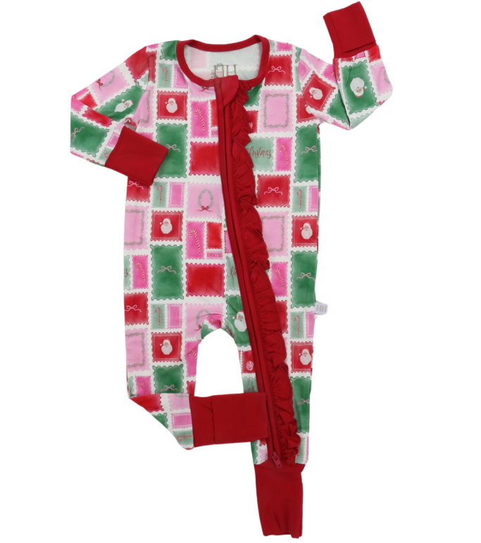 A baby long-sleeve footless pajama one-piece with a festive Christmas patchwork print in red, green, and pink, featuring a red ruffle down the front zipper and red cuffs and leg openings.