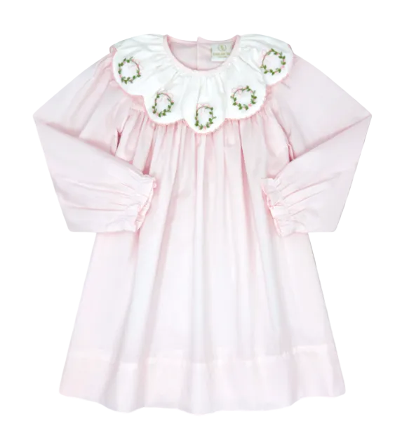 A light pink long-sleeve baby dress with a large white ruffled collar decorated with embroidered floral motifs, shown against a solid gray background.