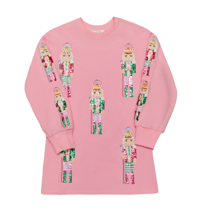 A pink crewneck sweatshirt featuring multiple sequined nutcracker soldier graphics printed across the front, displayed on a clean white background.