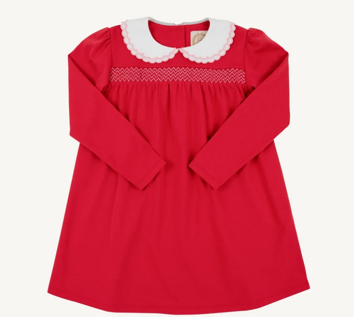 A red long-sleeve baby dress with a white scalloped Peter Pan collar and white smocked detailing across the chest, shown flat on a light cream background.