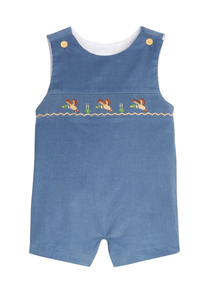 A baby's blue denim smocked romper with embroidered ducks and reeds across the chest, featuring gold snap buttons on the shoulder straps and a white inner collar, shown on a plain white background.