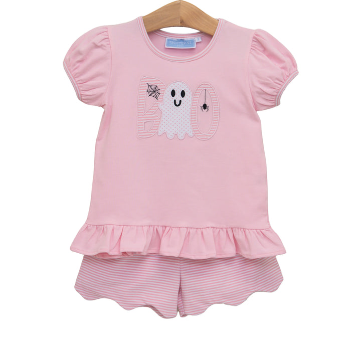 A toddler girl's two-piece pink outfit set featuring a short-sleeve top with a ghost and 'boo' applique design and a matching pink and white striped ruffled shorts set, hanging on a wooden hanger against a white background.