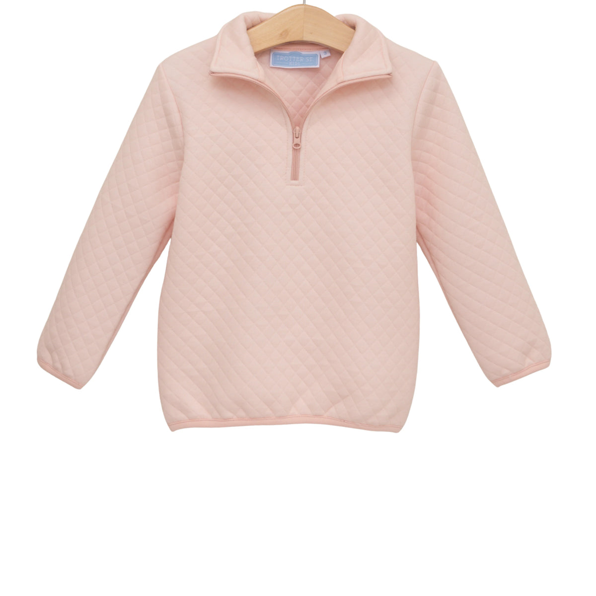 A light pink quilted long-sleeve quarter-zip pullover sweater hanging on a wooden hanger against a plain white background.
