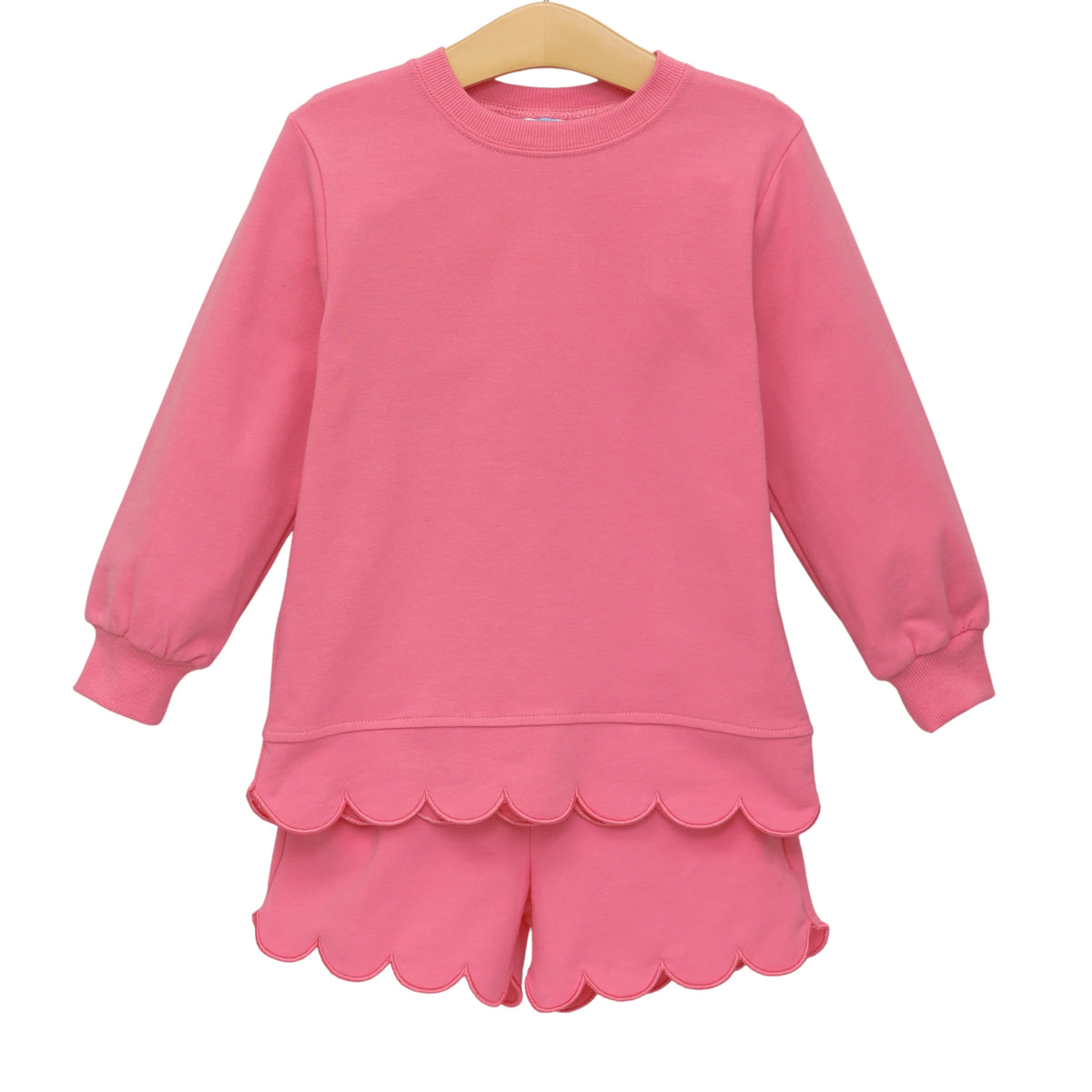 A pink long-sleeve top and matching shorts set for a child, featuring a scalloped hem and cuffs.