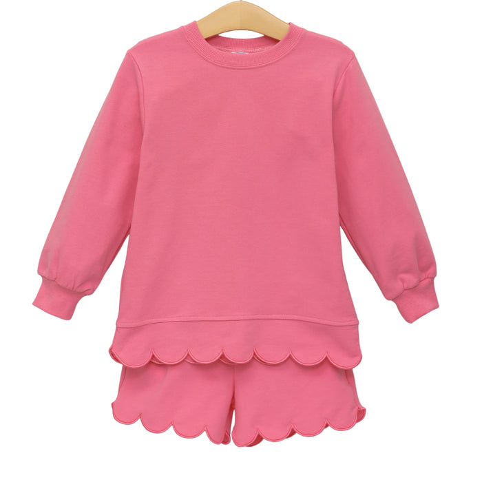 A pink long-sleeve top and matching shorts set for a child, featuring a scalloped hem and cuffs.