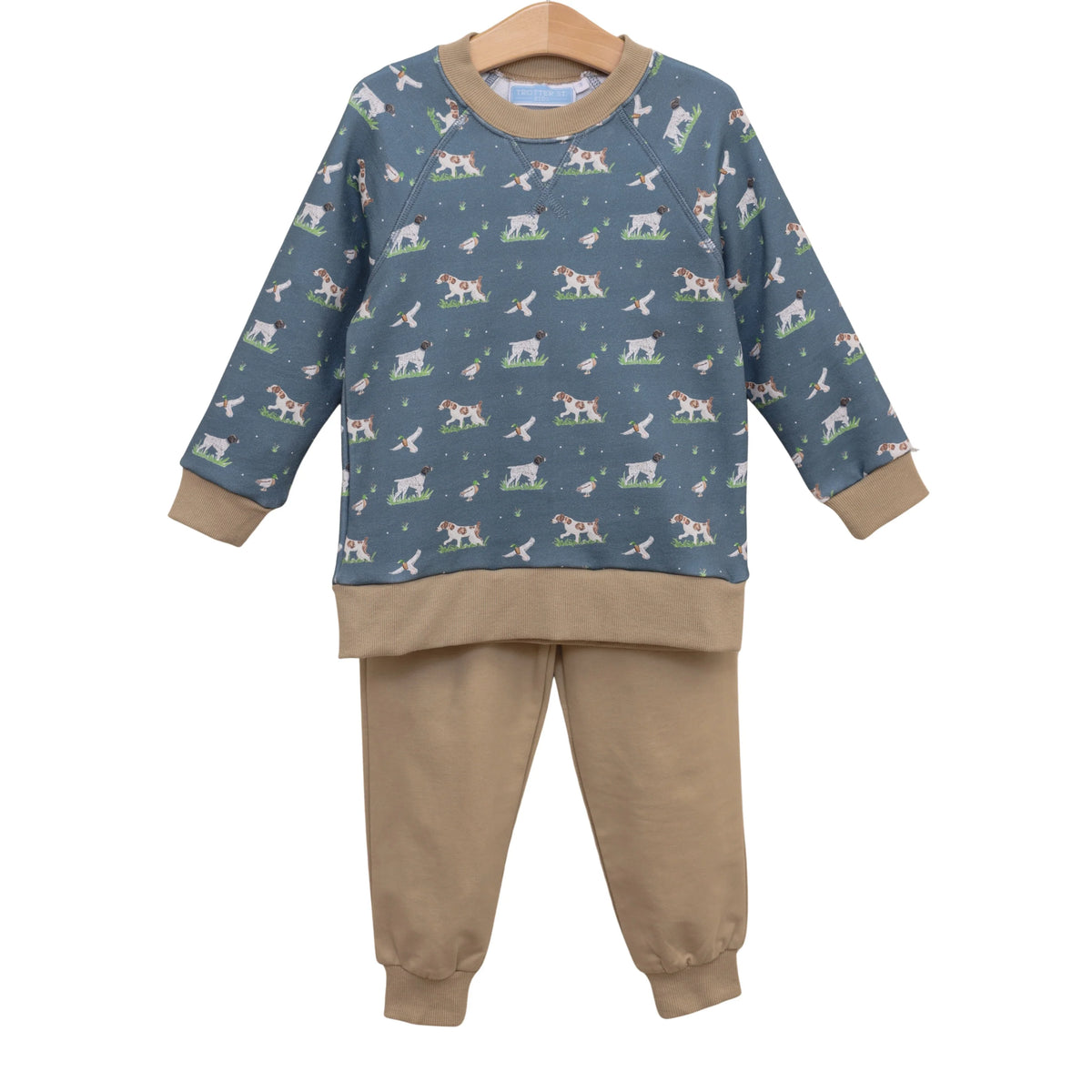 Children's pajama set with dog pattern on blue top and beige pants on a white background