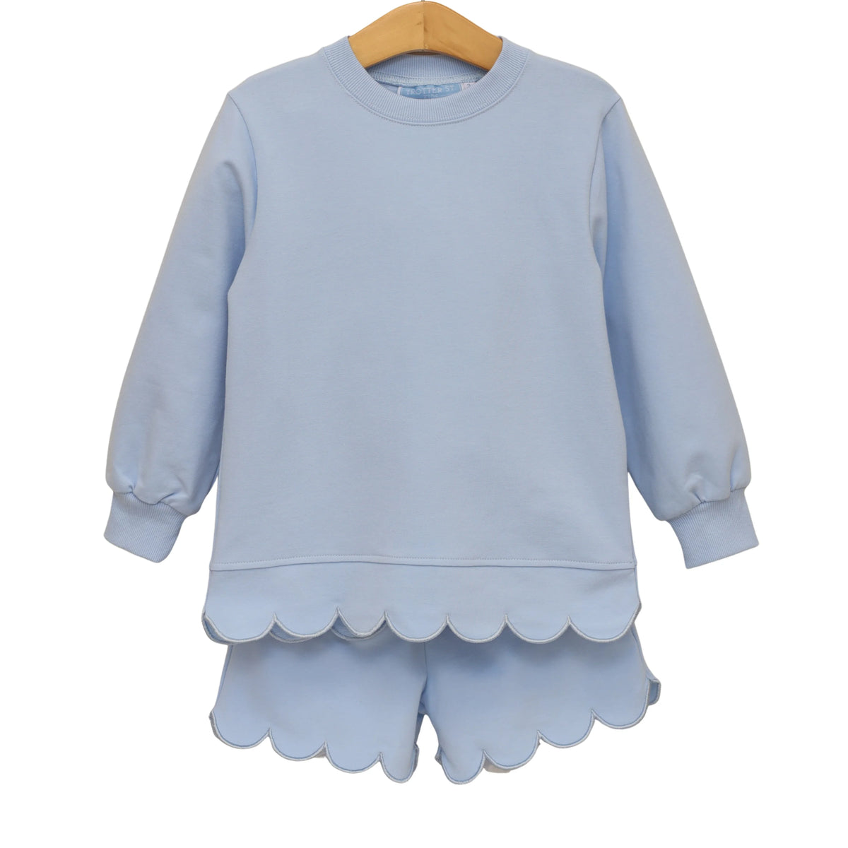 A light blue children's long-sleeve sweatshirt and matching shorts set hanging on a wooden hanger against a plain white background.
