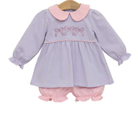 Baby dress with pink collar and embroidery on a white background