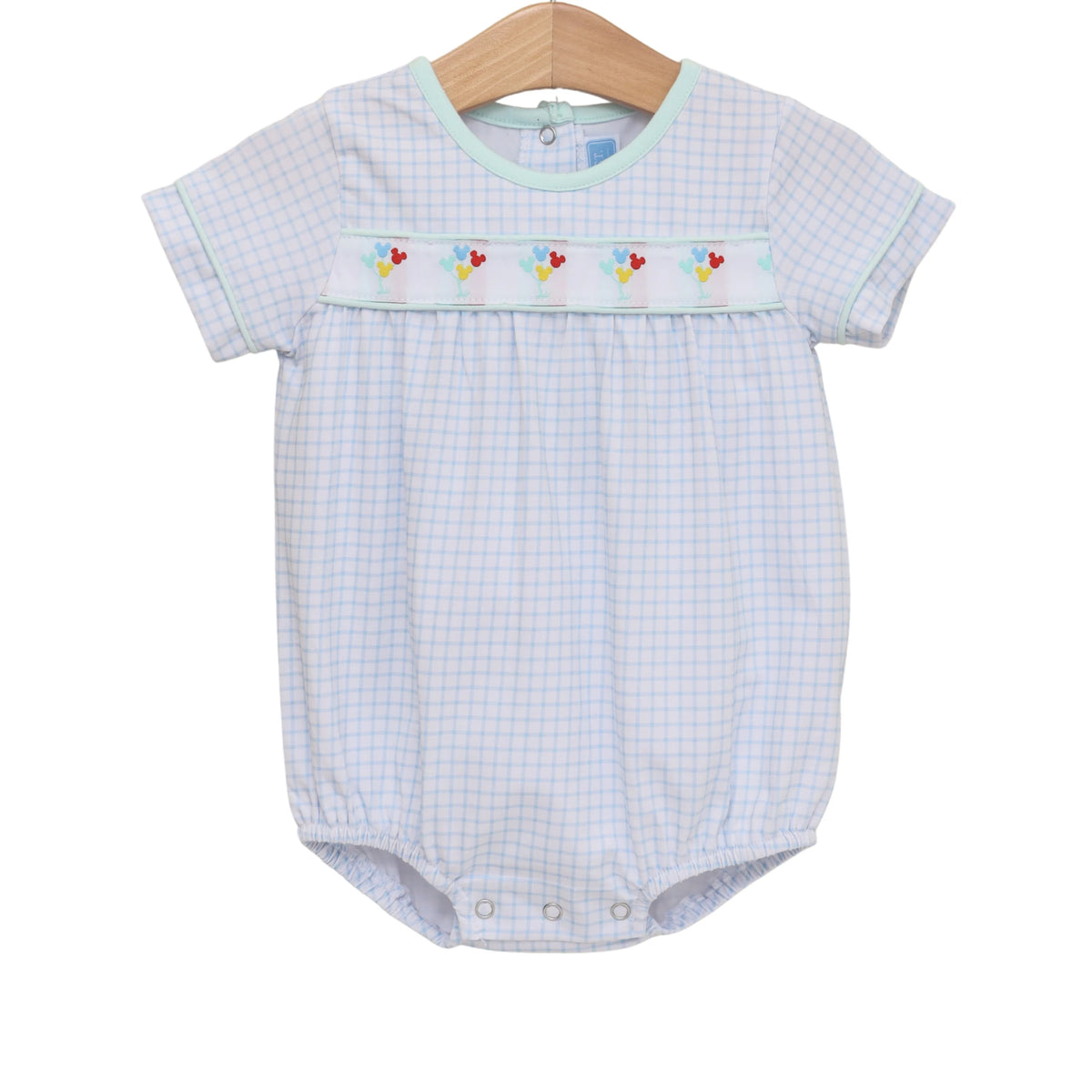 Baby romper with checkered pattern and embroidered details on a white background