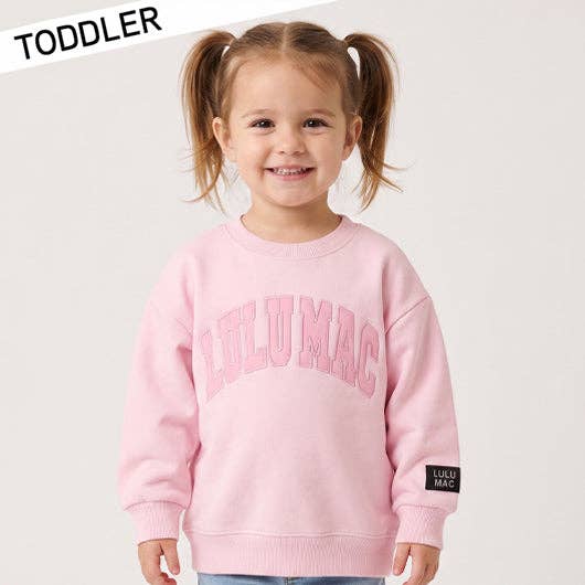 Toddler wearing a pink sweatshirt with 'Lulu Mac' branding on a white background
