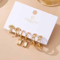 Set of gold earrings on a JOSSLYN branded card against a beige background
