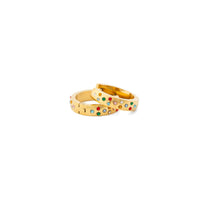 Gold rings with colorful gemstones on a white background
