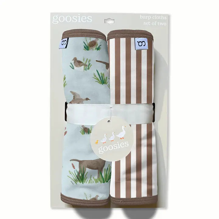 Goosies burp cloths set of two in retail packaging, featuring one light blue cloth with a duck and grass print and one brown-and-white striped cloth.