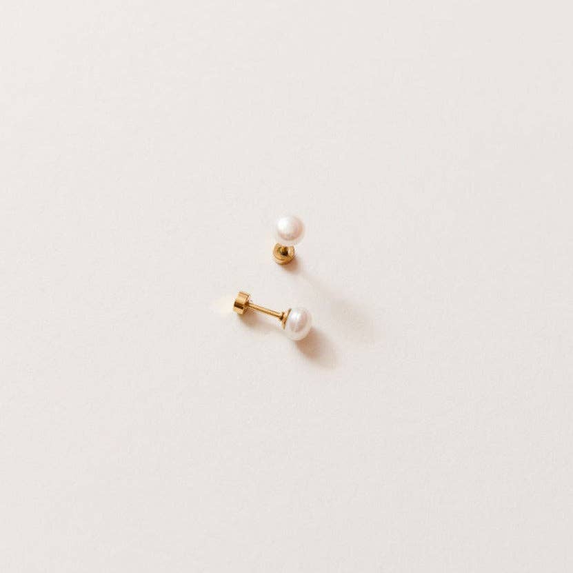 Pair of pearl earrings on a light beige background