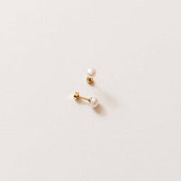 Pair of pearl earrings on a light beige background