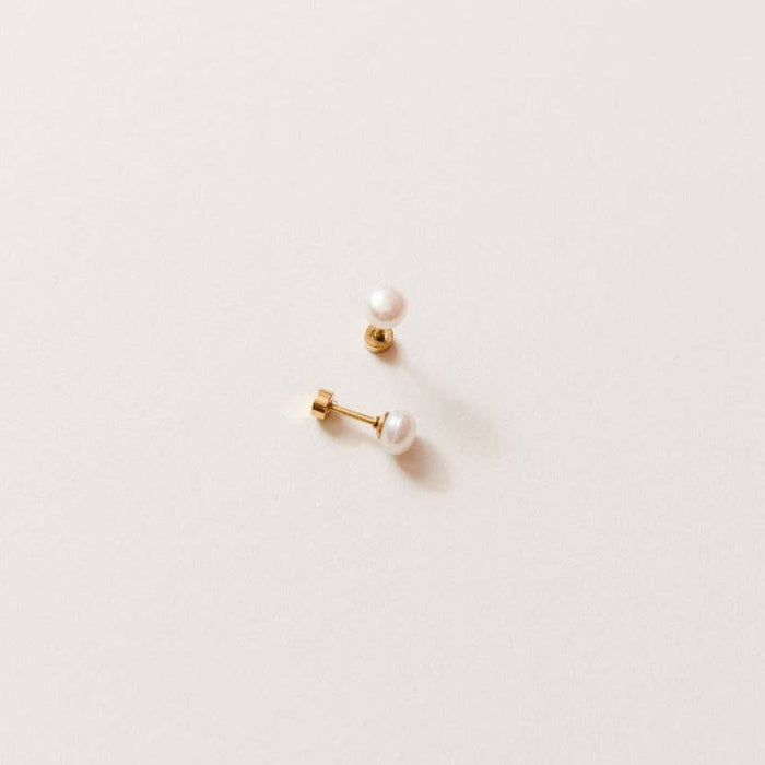 Pair of pearl earrings on a light beige background