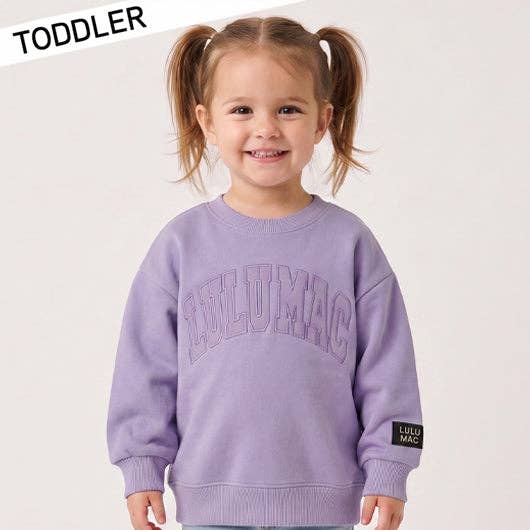 Child wearing a purple sweater with 'LULU MAC' branding on a white background
