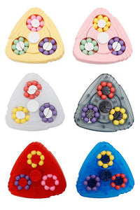 Six triangular plastic puzzle pieces arranged in a 2x3 grid on a white background, each featuring three circular bead rings in different color combinations: yellow and pink, white and gray, red and blue.