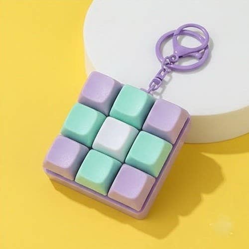 Square keychain with pastel-colored keys on a yellow background