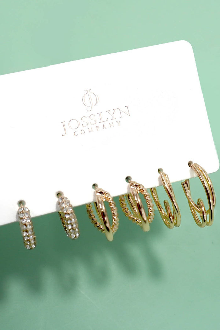 Set of gold hoop earrings on a Jocelyn Company card against a green background