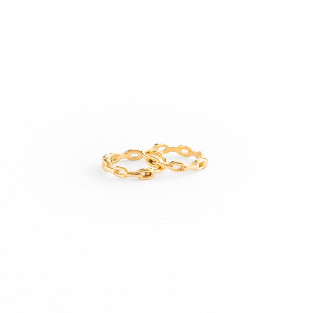 Two interlocking gold rings with a textured, open-link design, photographed on a seamless white background.