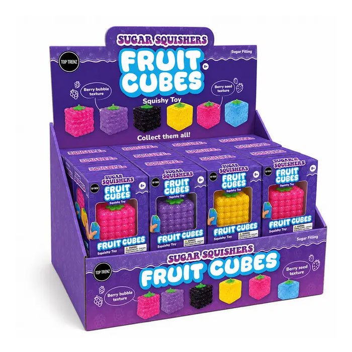 A purple retail display box filled with multiple small Sugar Squishers Fruit Cubes toy packages, shown on a clean white background. The display and boxes feature colorful fruit-cube graphics and text including 'Fruit Cubes' and 'Berry bubblegum flavor' and 'Berry seed texture'.