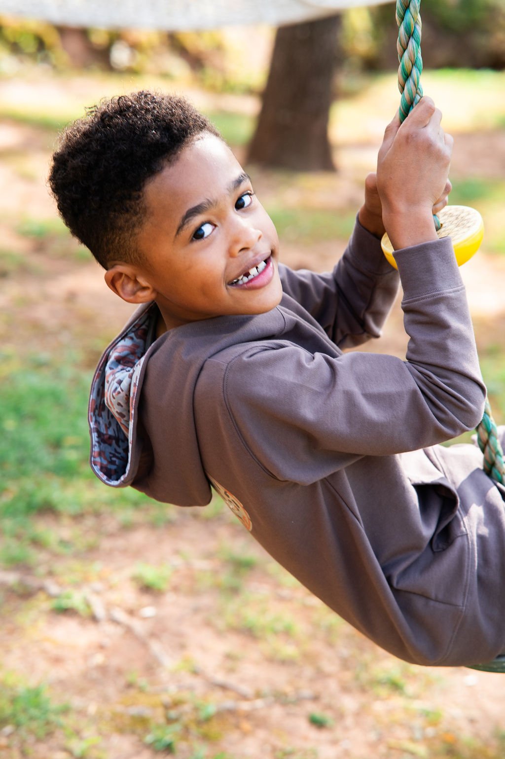 Child swinging on a rope swing in a park