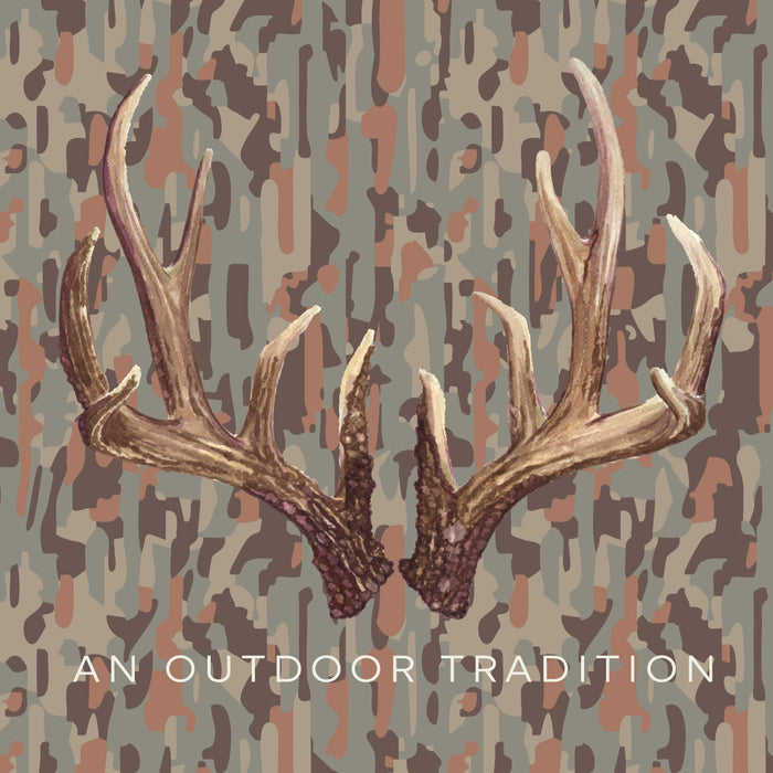 A pair of realistic deer antlers centered on a camouflage-style background in muted brown, beige, and gray tones, with the text 'AN OUTDOOR TRADITION' at the bottom.