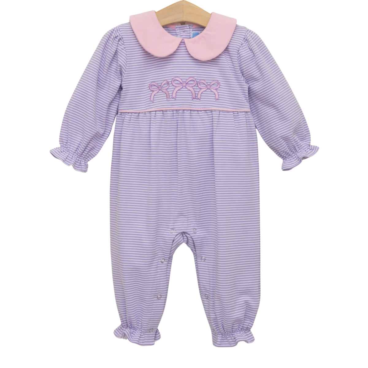 A baby girl's long-sleeve footless romper with lavender and white stripes, a pink Peter Pan collar, and pink bow embroidery on the chest, hanging on a wooden hanger against a white background.