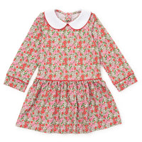 A long-sleeve children's dress with a pink and red floral print on a light beige background, featuring a contrasting white Peter Pan collar and red piping details.