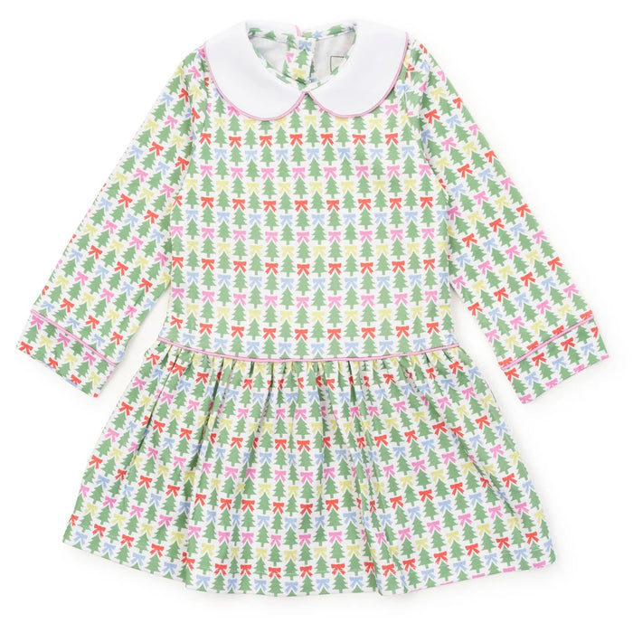 A long-sleeve baby dress with a white Peter Pan collar, featuring a green, pink, and red holiday pattern of Christmas trees and bows on a white background.